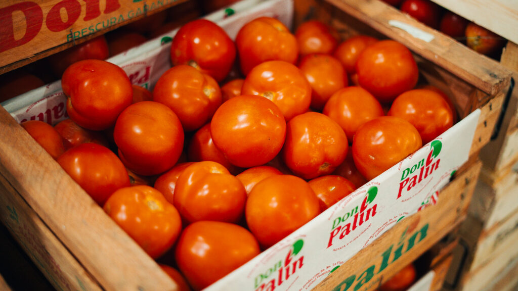 A close up photo of fresh tomatoes in a crate at Mercado de Productores in Rosario, Argentina.,
