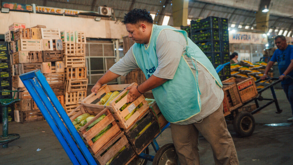 Nico Lopez, a staff member from Banco de Alimentos Rosario's market recovery program, RecupeBAR, collects surplus produce at Mercado de Productores Rosario. (Photo: GFN/