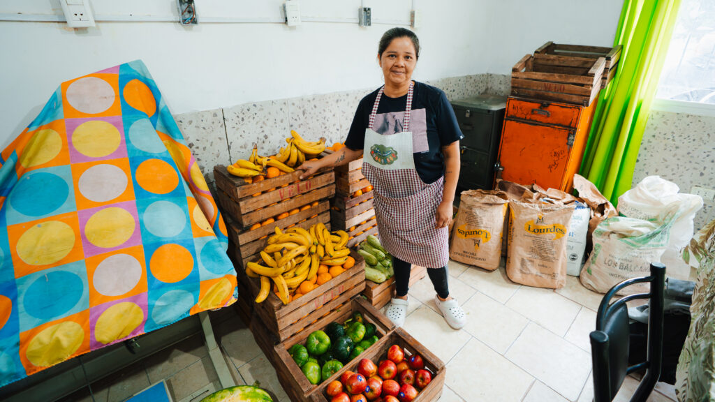Claudio Romero stands in front of fresh produce at the 9 de Julio Soup Kitchen