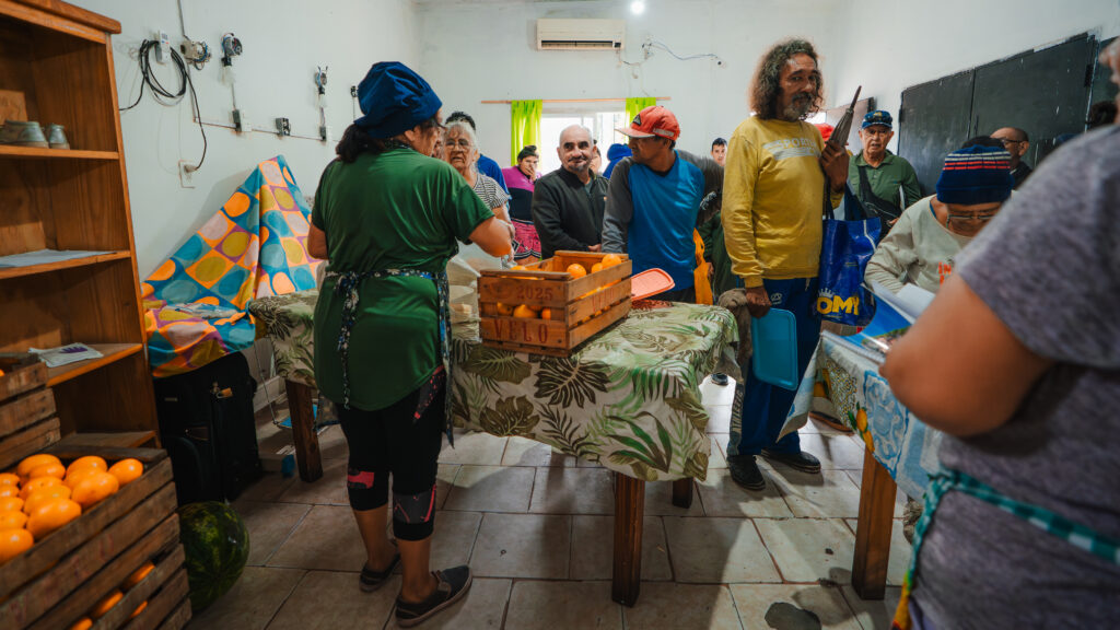Neighbors receive hot meals and fresh fruit from the 9 de Julio Soup Kitchen, which receives food from Banco de Alimentos Rosario. The soup kitchen feed 700 families per day.