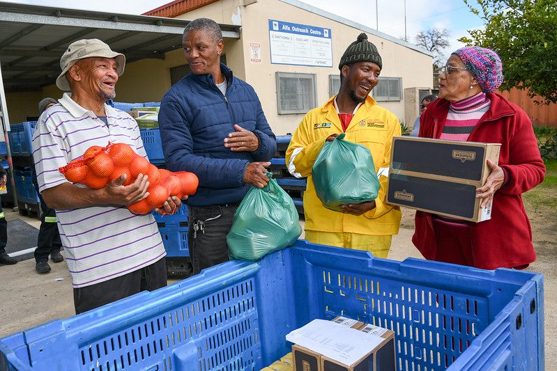 Cape Town, South Africa - 20250710 - (L-R) Geran le Fleur, Desmond Pypers, Christopher Vermeulen and Dibah Smith from Beneficiary Organisations collect their food from the FoodForward SA truck at the central pick-up point at the Alpha Outreach Centre in Malmesbury, near Cape Town, South Africa. The delivery is part of FFSA's Mobile Rural Distribution programme. Photo: The Global Food Banking Network / Jeffrey Abrahams